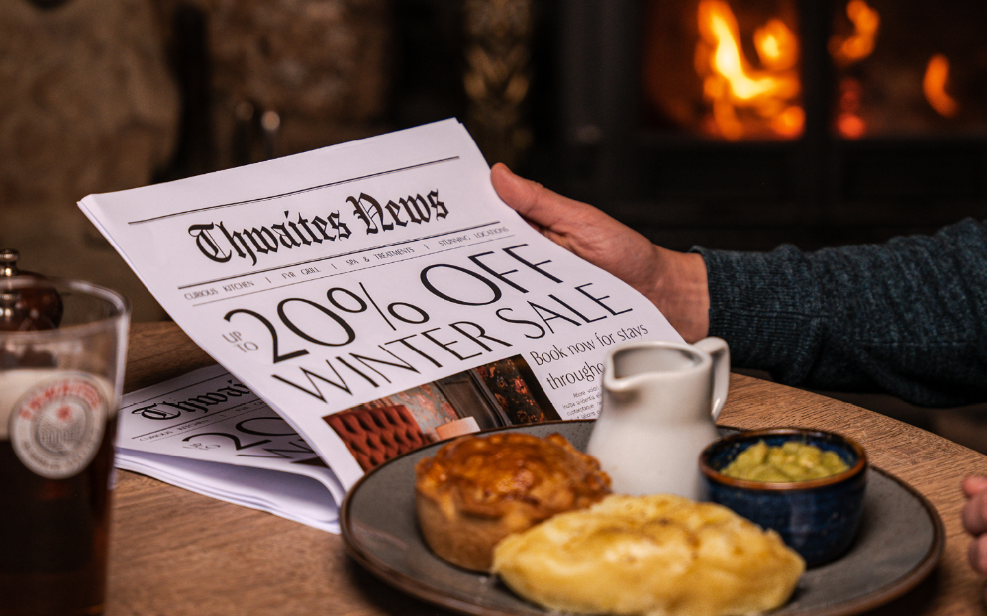 "up to 20% off this winter" newspaper with pie and a pint on a pub table